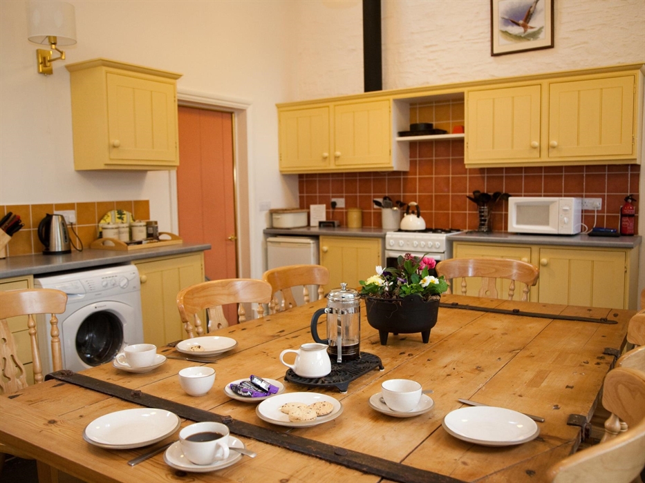 Open plan kitchen dining room with original wood features, ceramic hob cooker, fridge, freezer and pantry