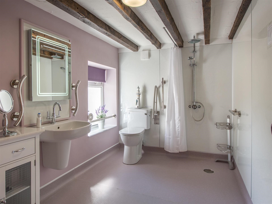 Spacious wet-room, none-slip flooring, grab tails next to comfort toilet, sink and shower. Shower chair available if needed.