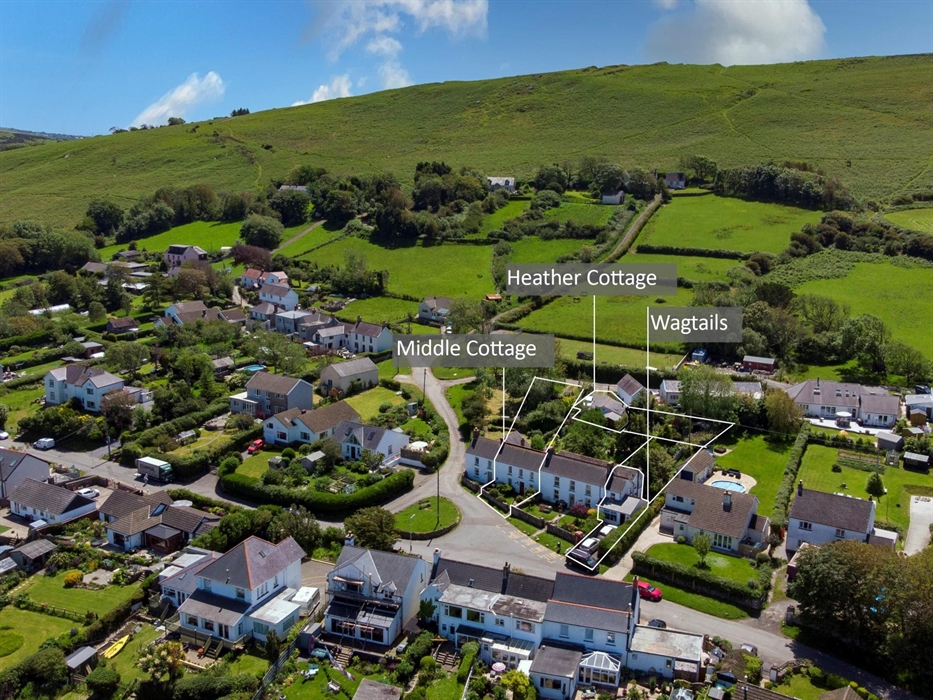 Sweeping green fields sloping down Llanmadoc Hill to Llanmadoc Village. Scattered white cottages. Welcome to North West Gower to Llanmadoc Village. Th