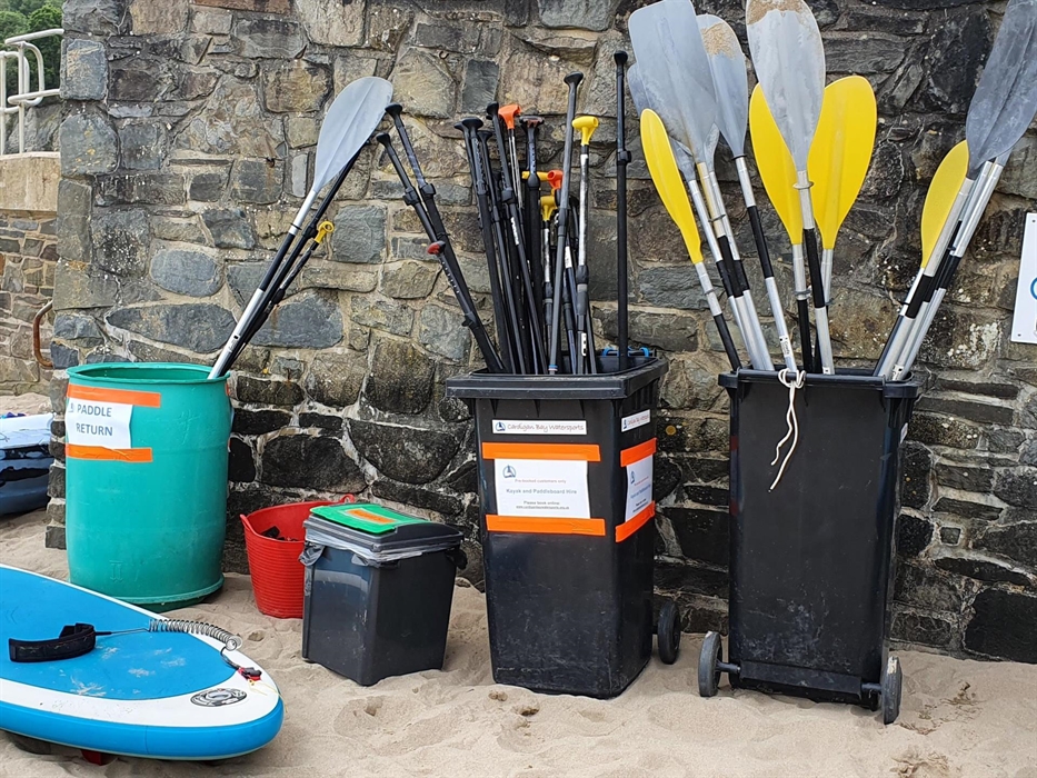 paddles and boards on the beach
