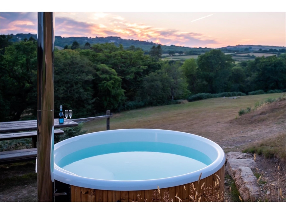 The view of the valley at sunset with a wood fire hot tub in the foreground