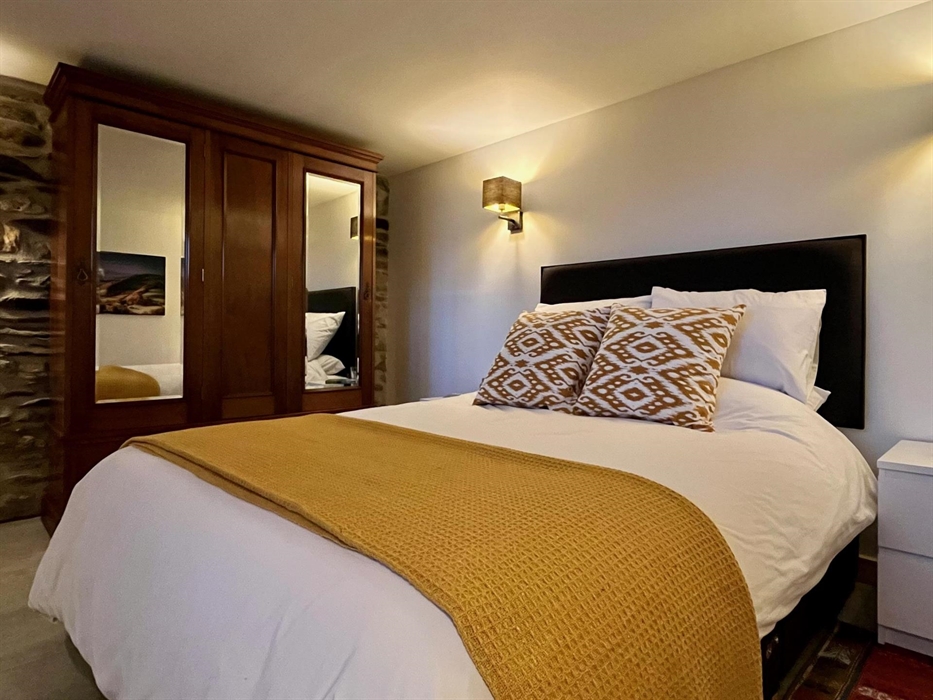 The bedroom includes a large wardrobe for storage