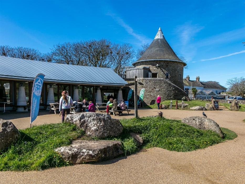 View of outside Oriel y Parc including gallery tower and visitors outside on picnic benches