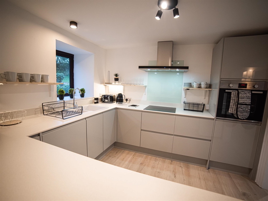 Prepare your meals in a modern, fully-equipped kitchen while enjoying morning conversations through a quaint hatch overlooking the breakfast bar area.