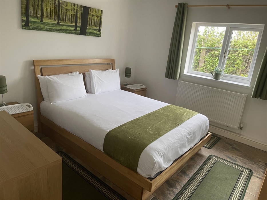 shows the king size bed, window overlooking the private garden, radiator, table lamps and 2 bedside tables.