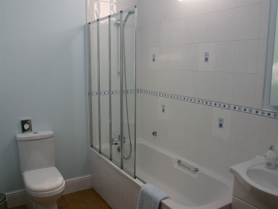 bathroom with shower over bath, toilet & sink