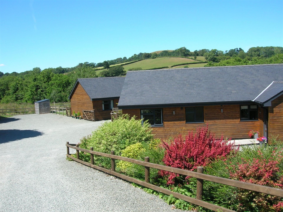 View from the drive, Woodland Lodge is the first one nearest to the shrubs and then River Lodge is slightly further on with a fully grown hedge betwee