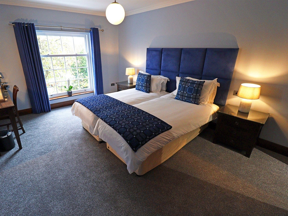 Lena room is a superior room in the Morgans Townhouse which can be twinned. Image shows the spacious bedroom with a twin-bed, ample lighting from the