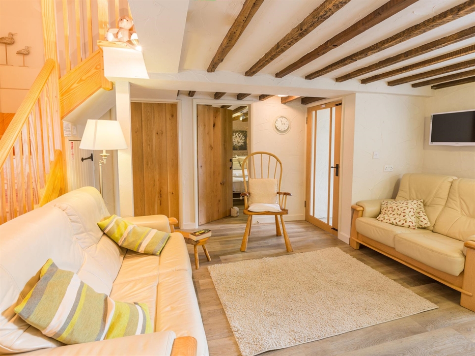 Stangwrach Cottage living room image, beamed ceiling, leather sofas, Easy to clean flooring, removable rugs. Stairs to first floor twin and double roo
