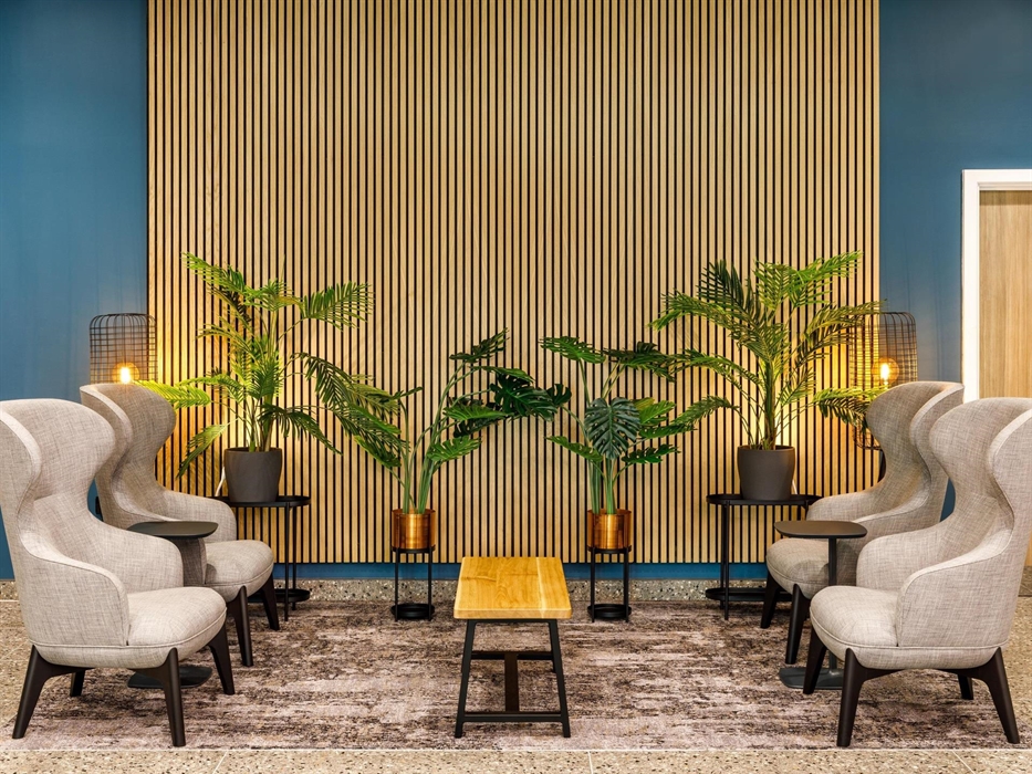 Hotel lobby with chairs, foliage and lanterns