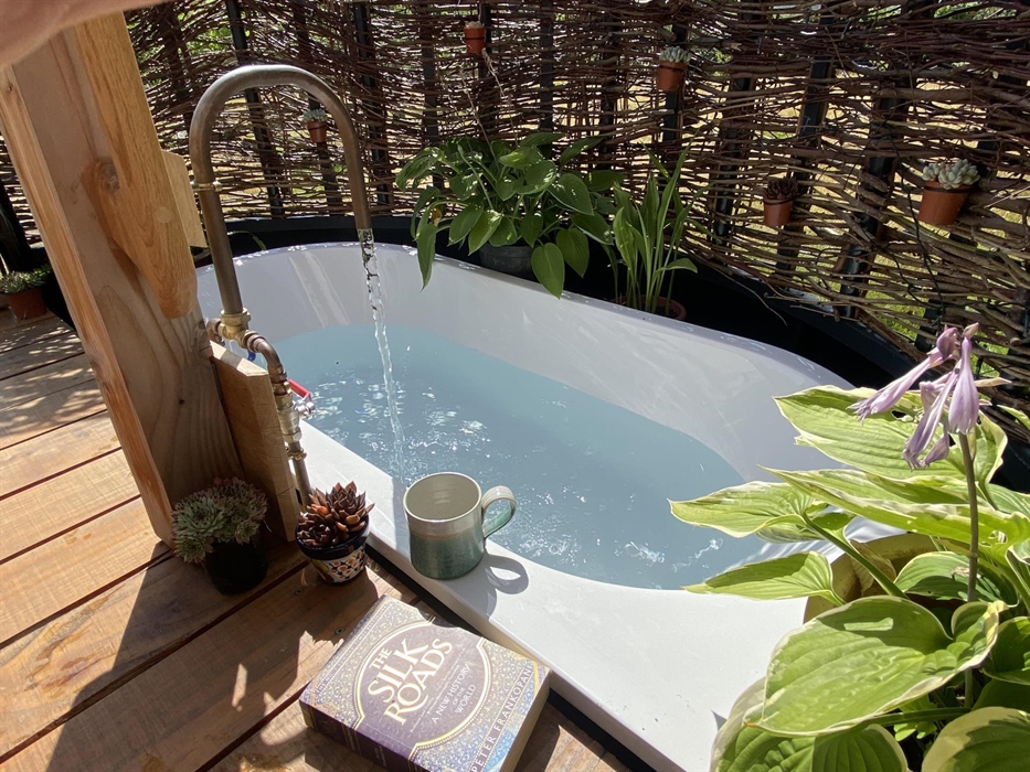 Outdoor bath at one end of deck area and verandah.