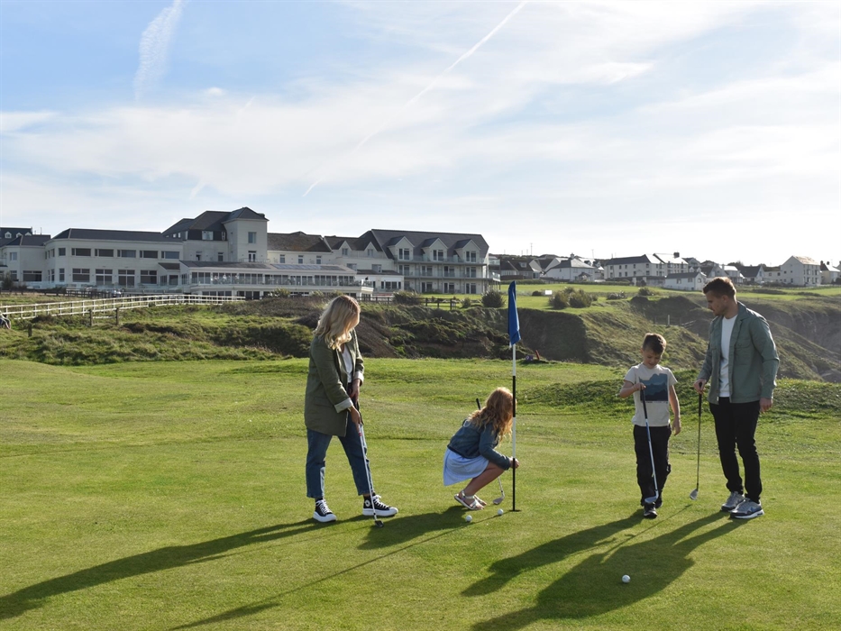 Family playing golf on the 9-hole course at The Cliff Hotel & Spa