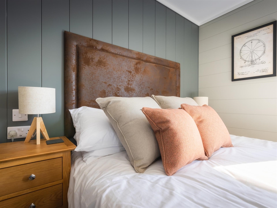 Double bed with vintage fairground artwork on the wall