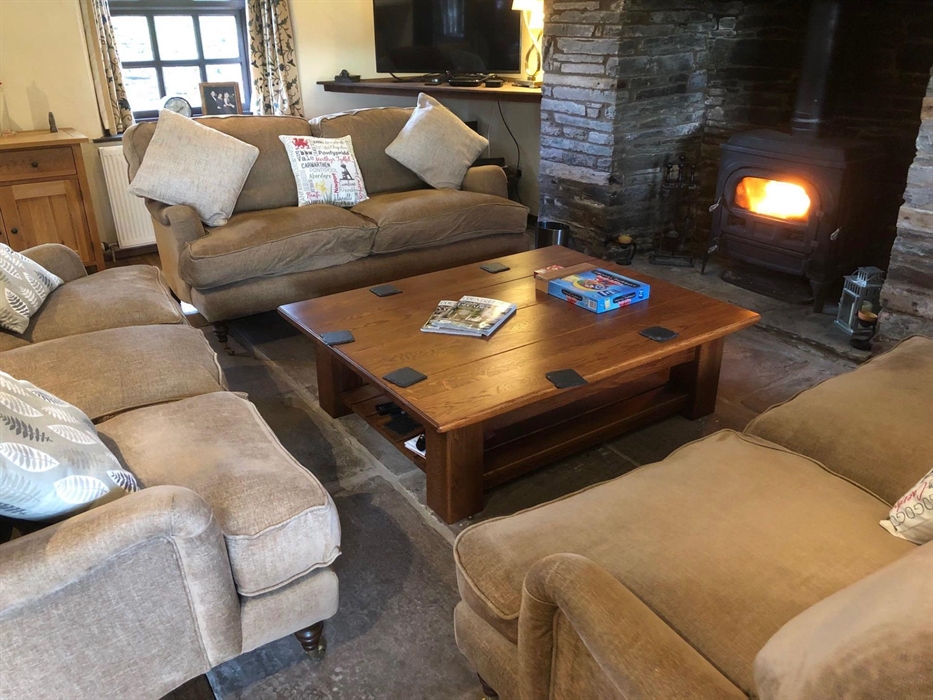 The Farmhouse at Hilltops Brecon Holiday Cottages has a ample sofas, a log-burner and fully fitted kitchen