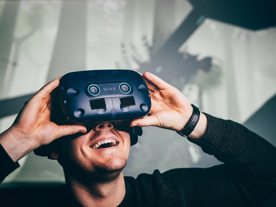 young man, smiling, wearing virtual reality headset