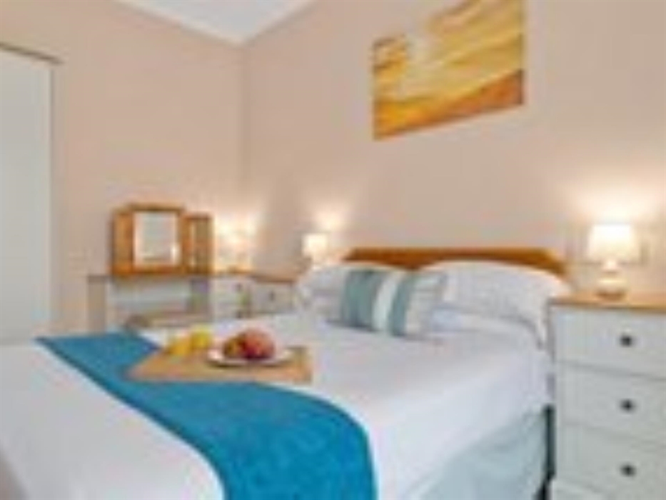 A photograph of the main double bedroom in apartment 2 showing a breakfast tray on the bed and the beach themed decor