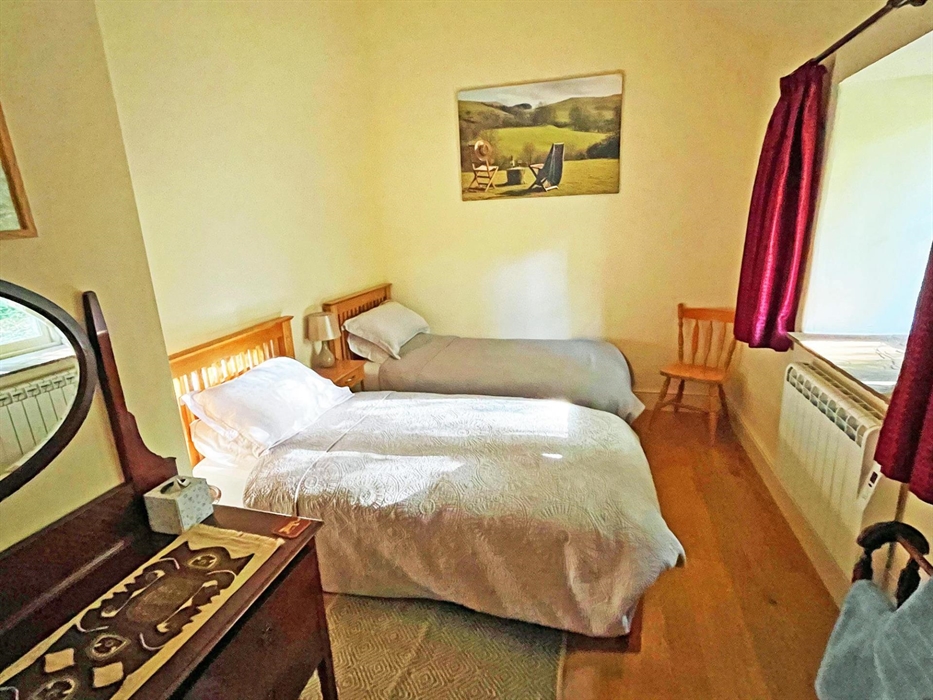 Contions twin single beds, dressing table, heater, towel rail rugs bedside tables and lamps.