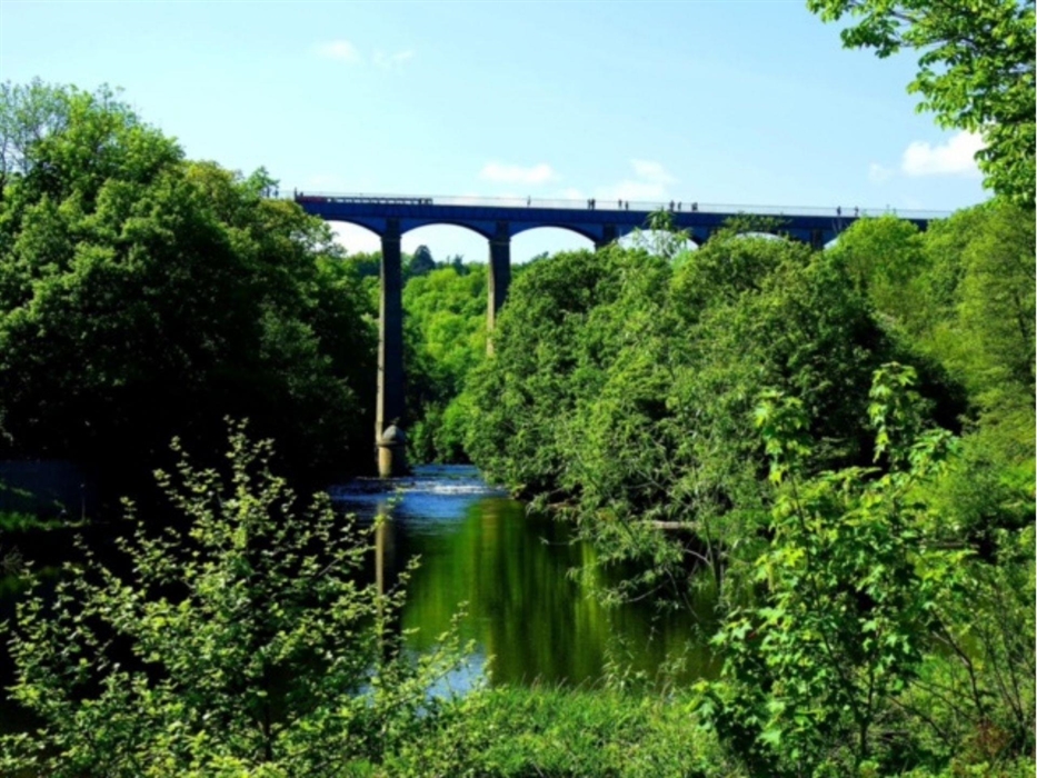 A view of the Poncysyllte Aqueduct, canal boats and people crossing it.
