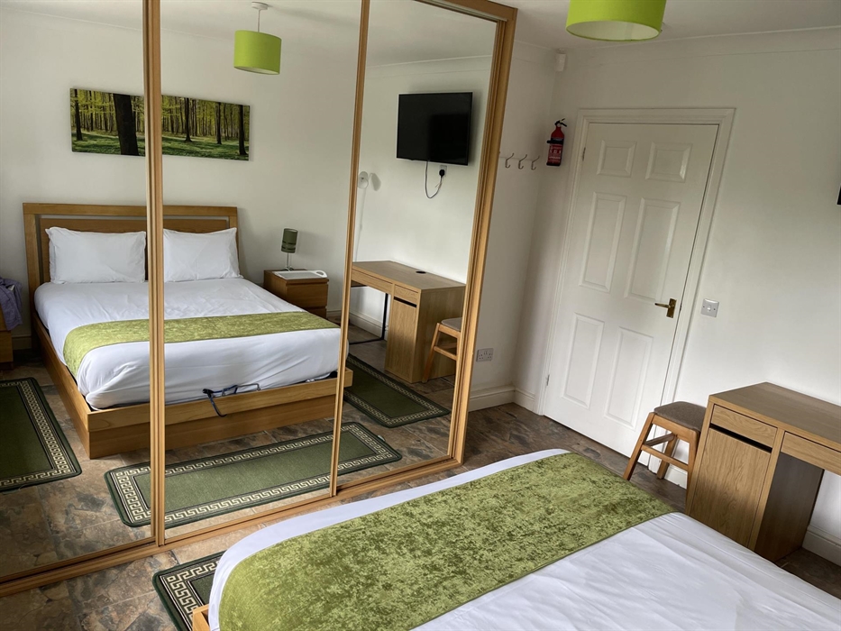 shows UK king size bed, 2 bedside cabinets, writing desk, stool (office or wooden chair available on request), mirror wardrobes and 43" Smart Tv with