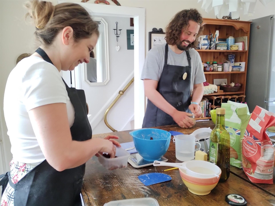 Class participants practice breadmaking techniques in Warren's kitchen in Radyr, Cardiff.