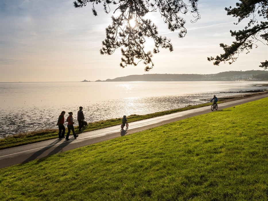 Cyclist and walkers on Coast Path at Blackpill at sunrise
