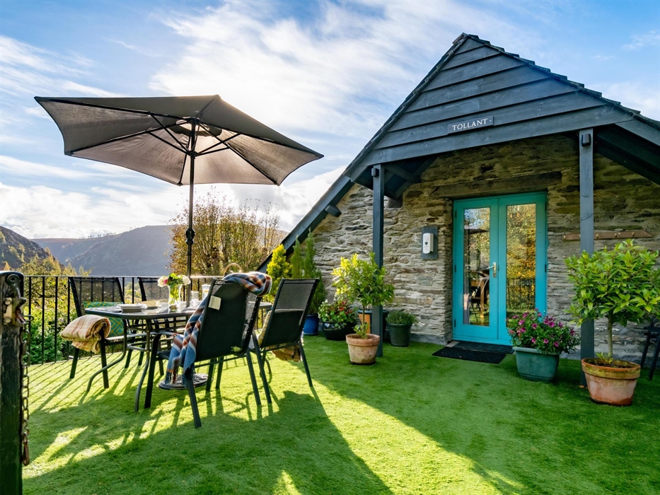 Sunny deck with outdoor furniture and plants. Great views of the hills.