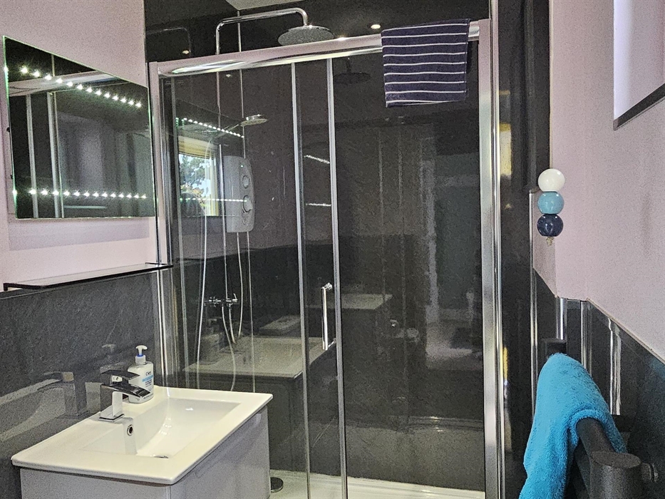 The bathroom has a large, electric, walk in shower