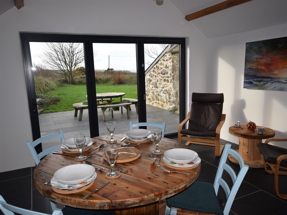 Dining table, French windows fold back fully for access to private patio. Faces south west.