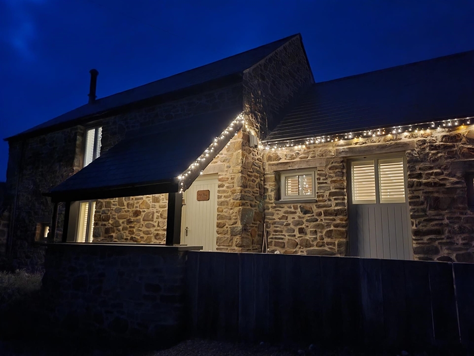 The Mill House looking warm and welcoming with outside fairy lights on in winter.