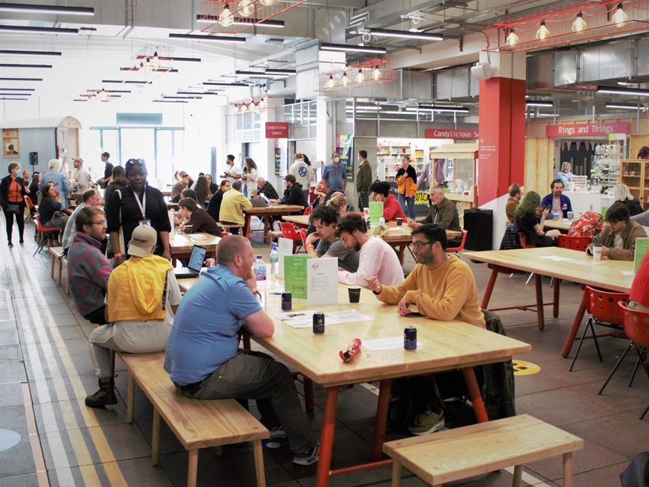 Groups of people sat at various tables in Tŷ Pawb's food court
