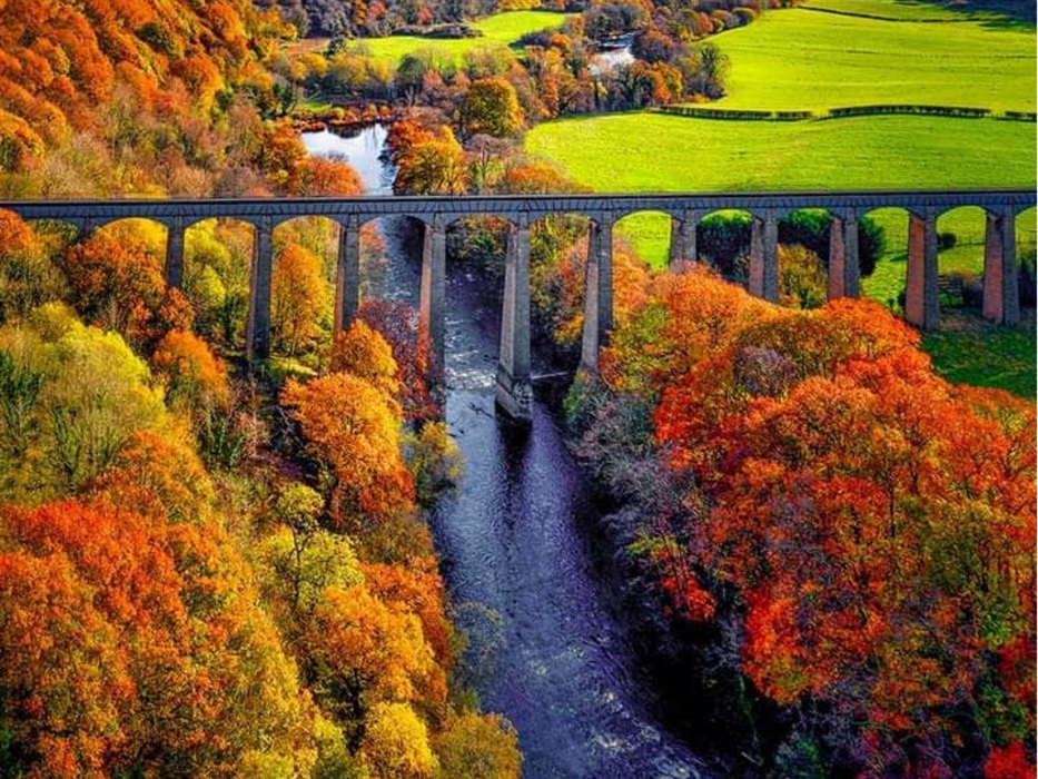 An aerial view of the iconic Pontcysyllte Aqueduct with the river Dee flowing below it and the beautiful countryside.