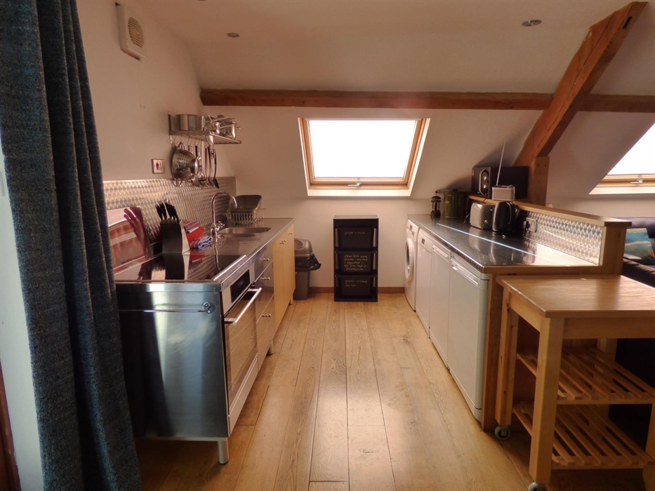 Sociable cooking in the open plan Tollant kitchen. This spacious barn conversion is a great place for getting together with friends.