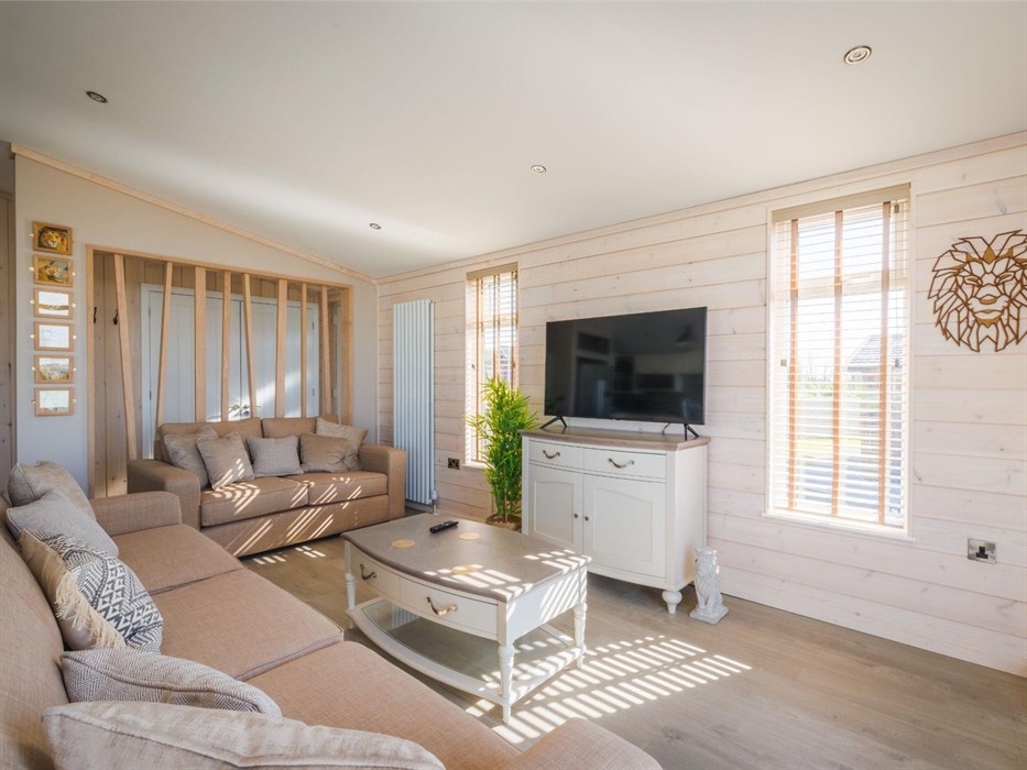 Living room with sofas, coffee table and flat screen TV with lion-themed interior styling