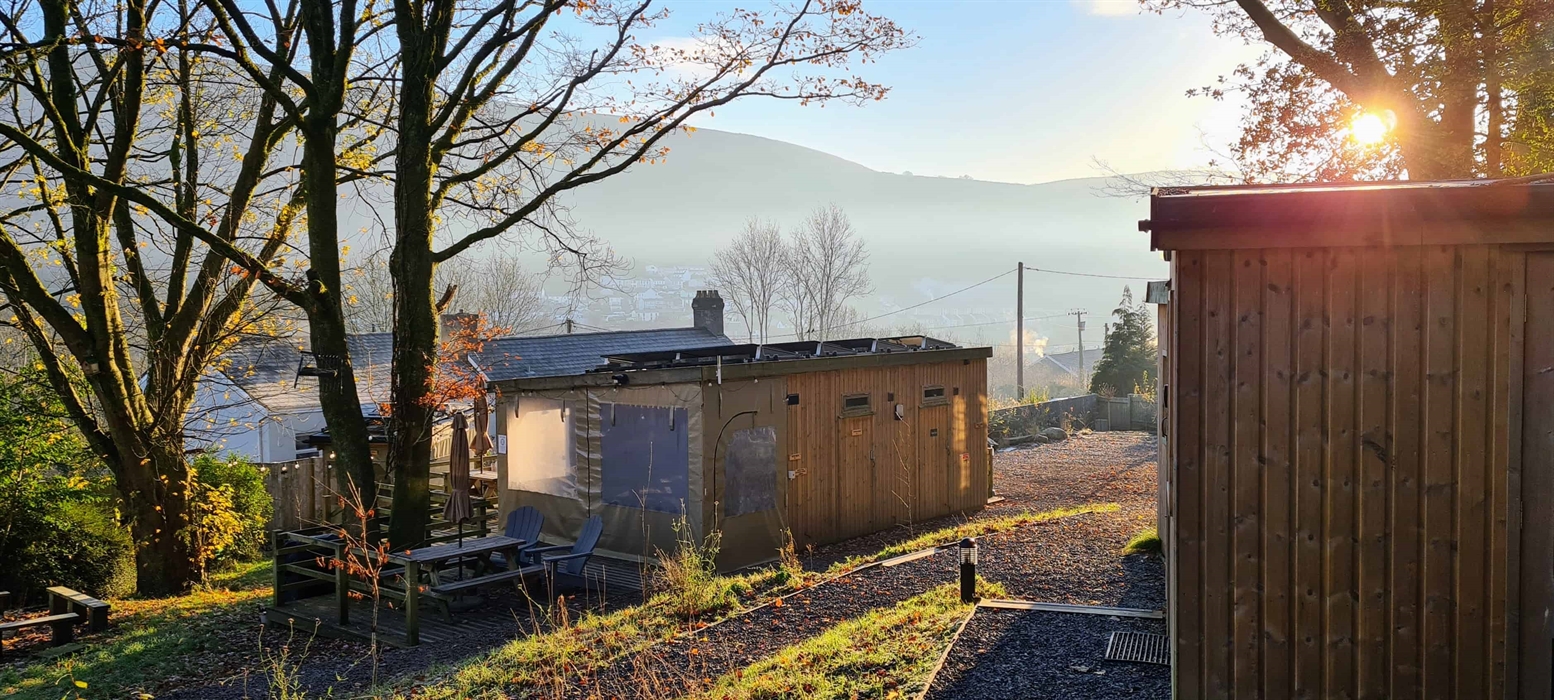 wooden cabins among bare trees on a crispy hazy morning