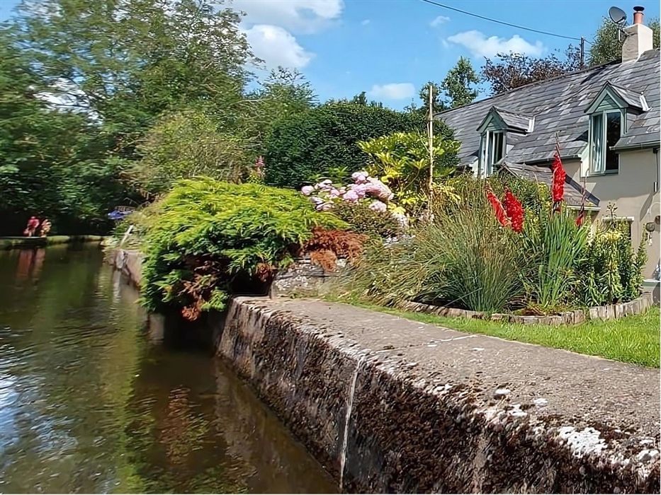 Canal side scenic view as the horse drawn boat travels a long the Llangollen canal surrounded by trees and flowers surrounding one of the canal side c
