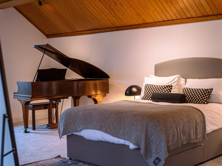 The grand piano in the bedroom adds a touch of elegance and the promise of melodious serenades amidst a serene setting.