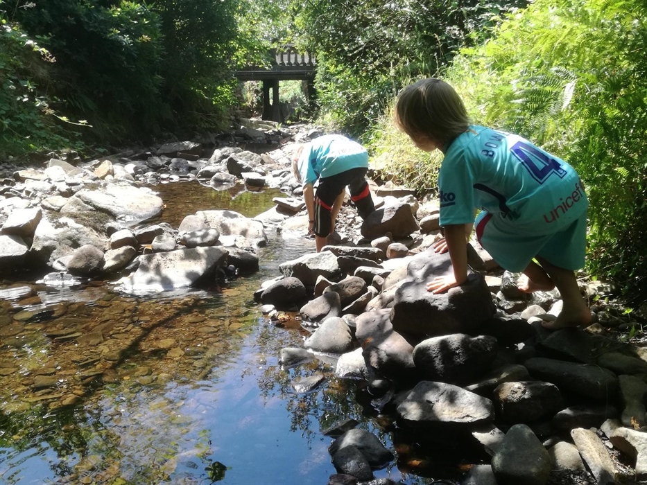 Children playing in the River Clydach alongside Y Stabl holiday cottage on Plas Farm in the Swansea Valley of South Wales