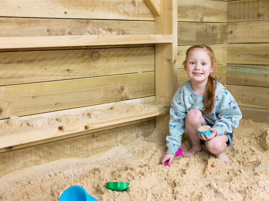 girl playing in sand pit