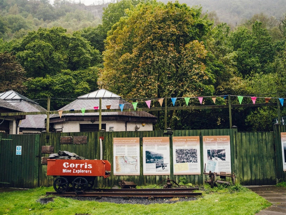 An old slate truck and information boards outside of Corris Mine Explorers based at Corris Caverns in Mid Wales
