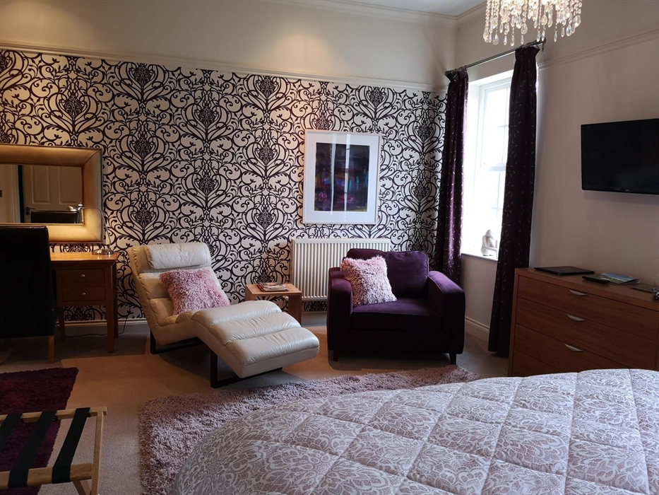 The Cherry Suite has a super-king size bed which can be converted to twin beds, a comfortable seating area. a flat screen smart TV and tea/coffee maki