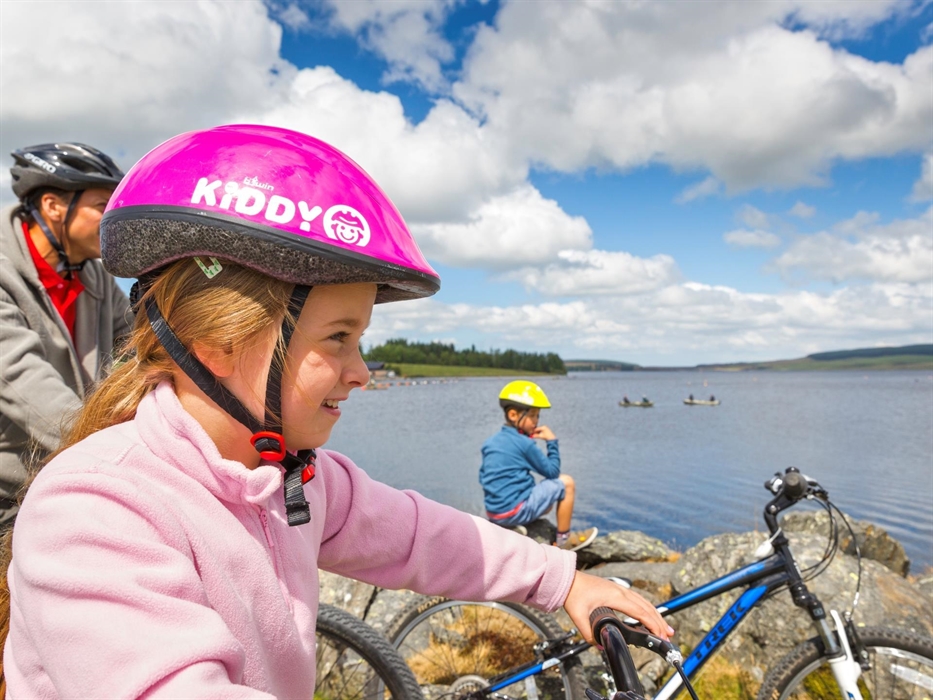 Family pausing to enjoy view over lake Llyn Brenig Cycling Conwy