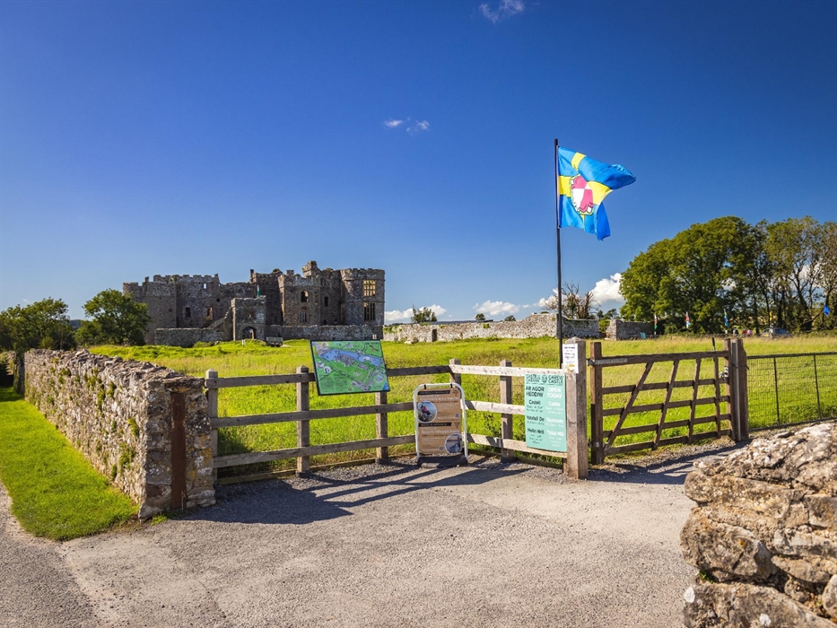 Image of the front of Carew Castle with the Pembrokeshire flag.