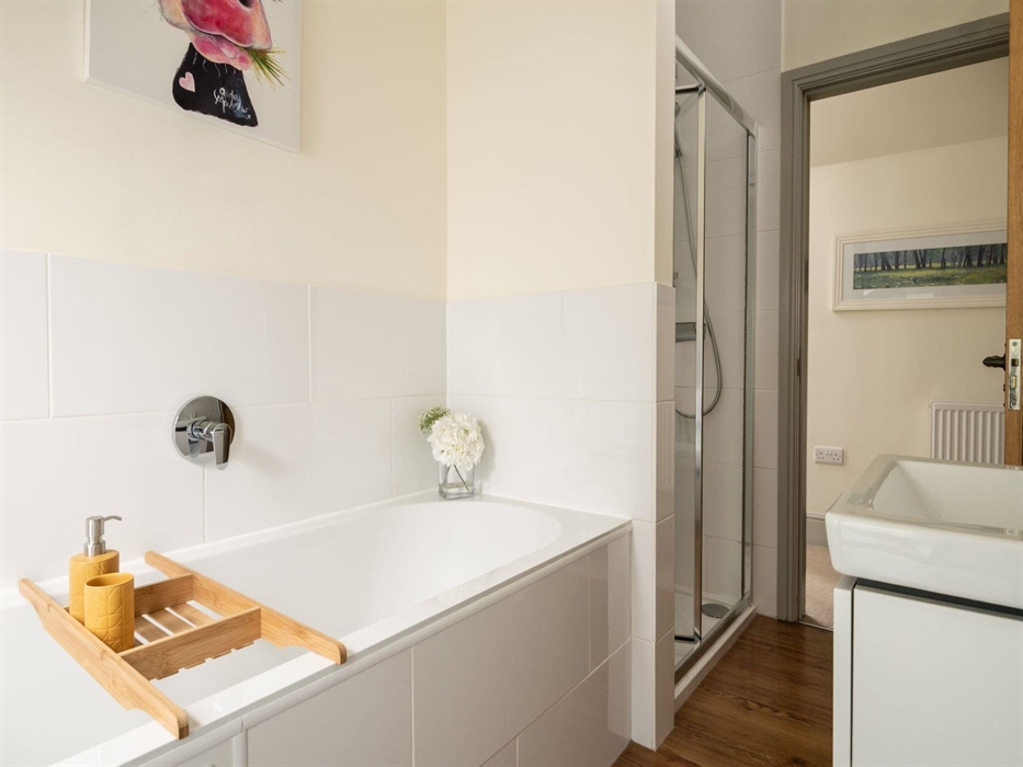 Main bathroom comprising of a bath and shower with complimentary toiletries from 'The white company'
