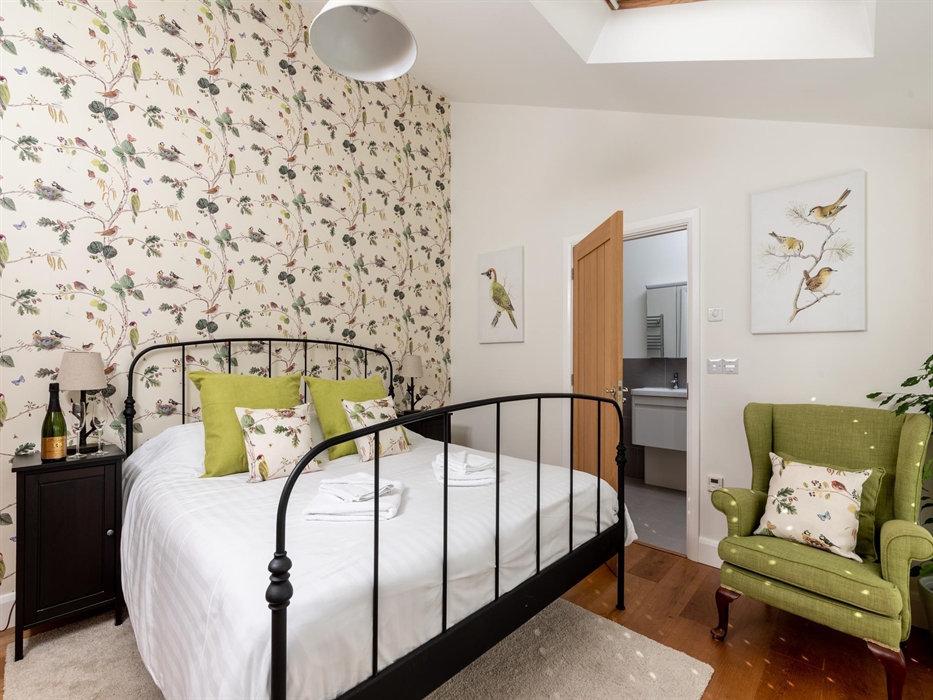 Our downstairs bedroom with a super-king bed really is a nature lover’s paradise. French doors with wooden shutters lead directly into the huge walled