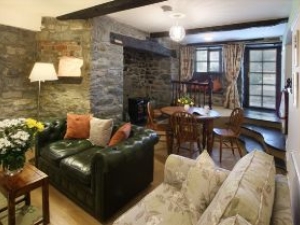 The Searle sitting area provides a comfortable sofa and reclining chair.  It's inglenook fireplace hosts a feature log effect electric fire and gives