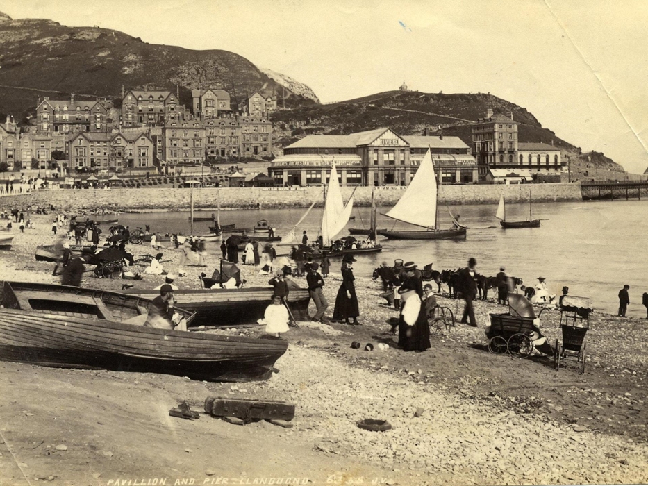 The Pier Pavilion in the background, sailing boats offering trips around the bay and donkey rides along the beach.