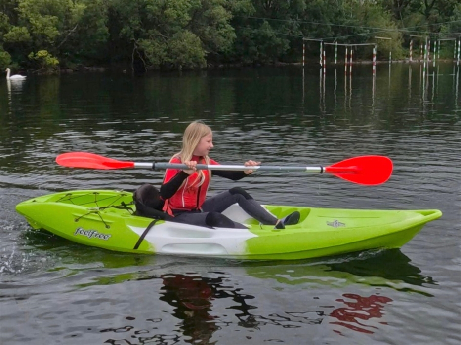 Picture of a girl paddling a green kayak