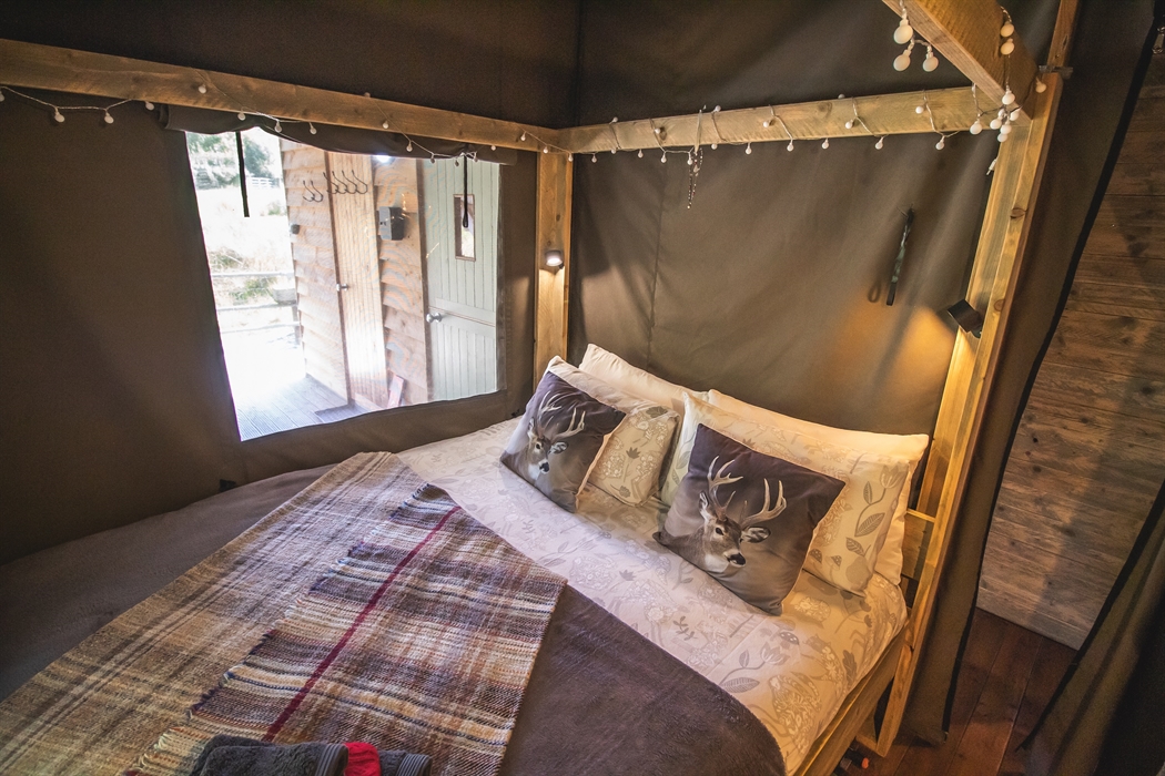 King size four poster bed with fairy lights and a view.