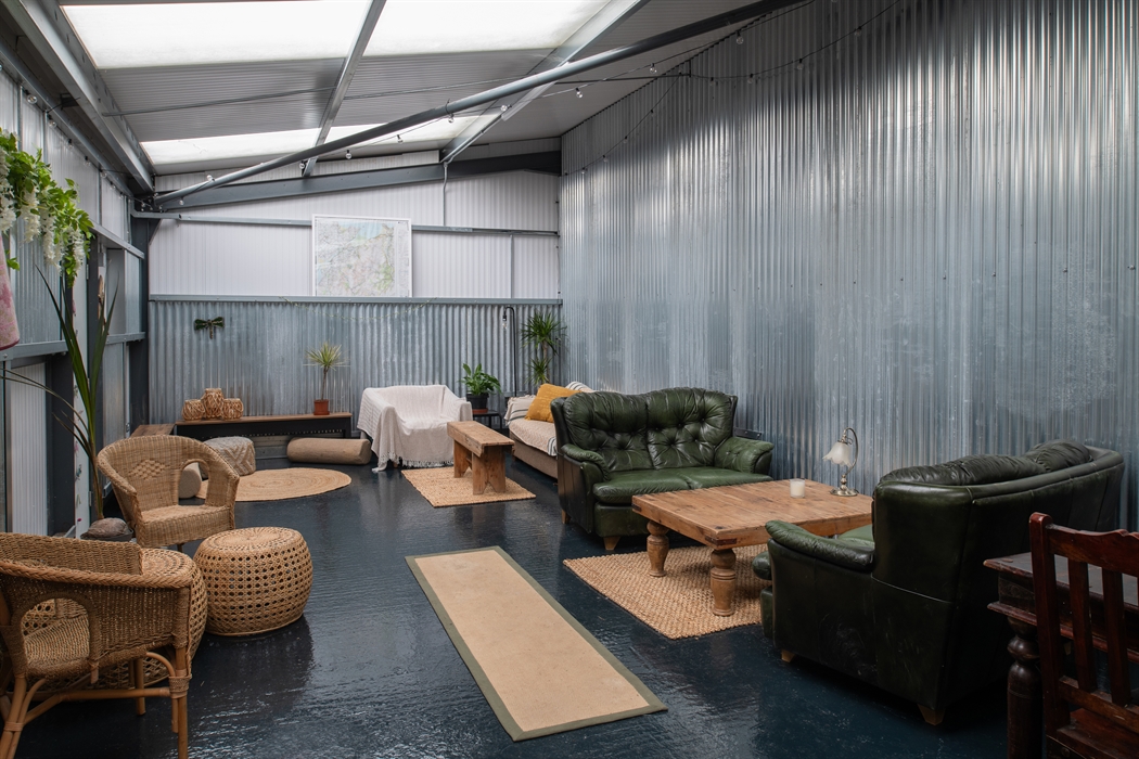 Inside a communal shed with sofas, tables, rustic furnishings and games room