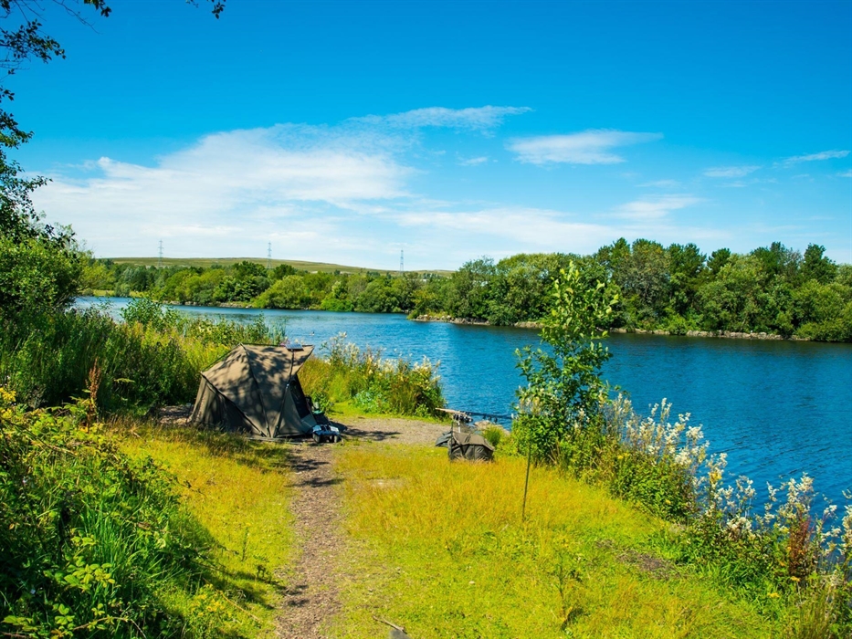 Fishing from the banks of the lake at Parc Bryn Bach.